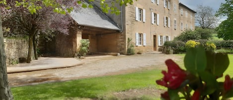 A stone building with multiple windows and a covered entrance.