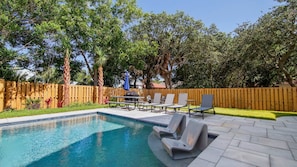 A backyard with a swimming pool, lounge chairs, and a wooden fence. - Laguna Dreamin' 226-Private Pool-Sleeps 10 (Panama City Beach)