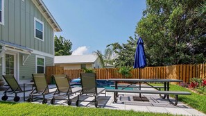 A backyard with a pool, lounge chairs, a picnic table, and a wooden fence. - Laguna Dreamin' 226-Private Pool-Sleeps 10 (Panama City Beach)