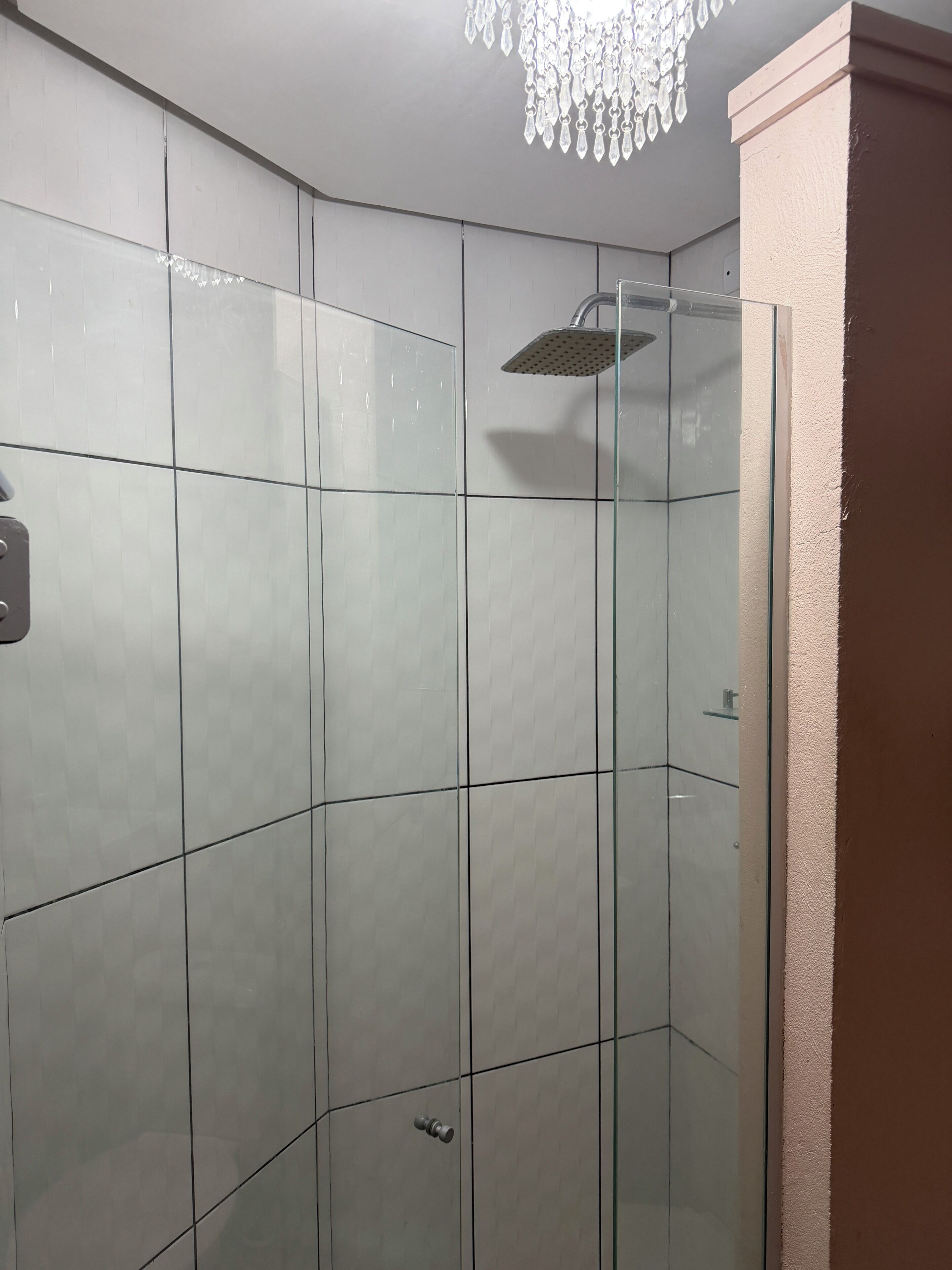 Eine Dusche mit Glastür und einer Deckenbrause.