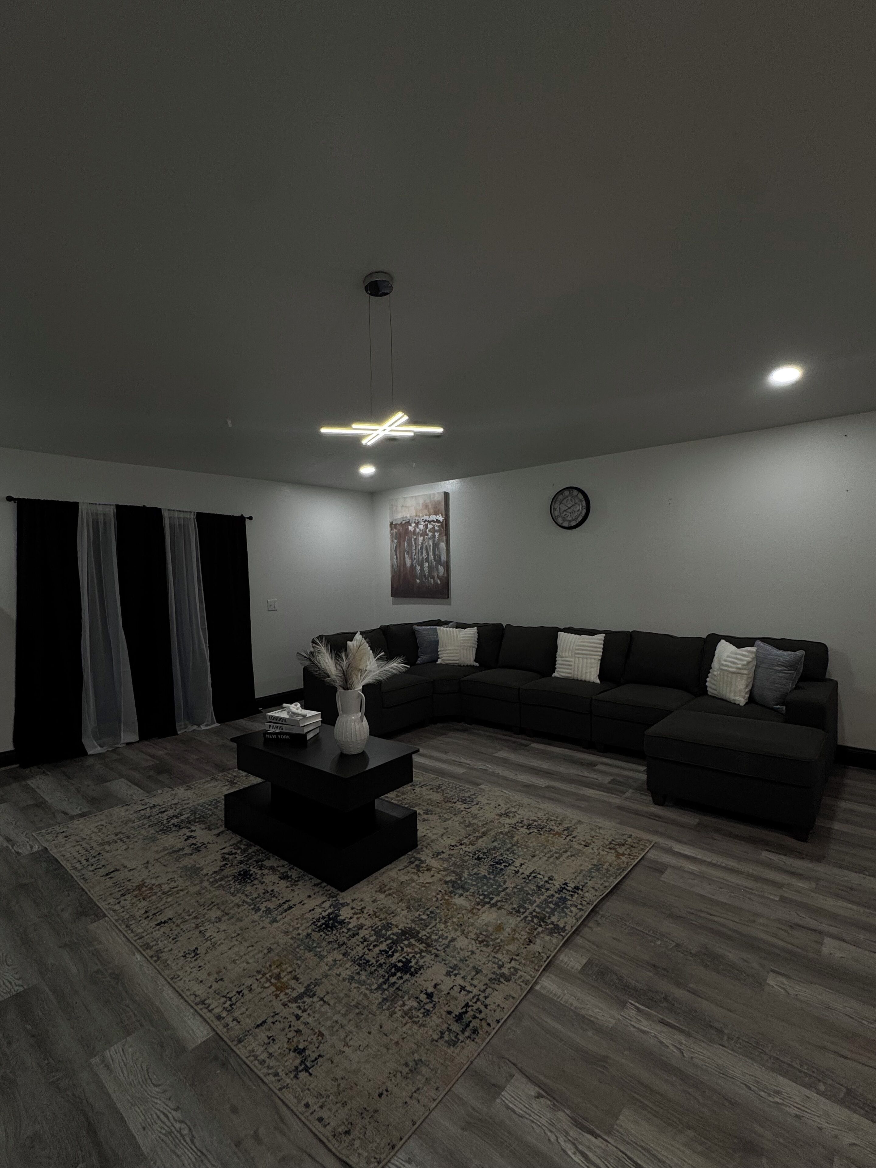 Un salon moderne avec un canapé d’angle, une table basse et un tapis.