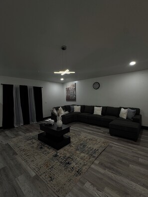 Uma sala de estar moderna com um sofá seccional, uma mesa de centro e um tapete.