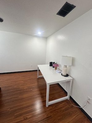 A room with a white desk, a lamp, and a small plant. - Remodeled 4BR Home– 2 FloorsExpansive Retreat 4BR 3.5BA Perfect for Groups (Ocala)