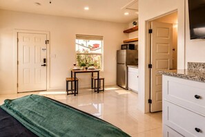 A compact kitchen with a dining area, a refrigerator, and a microwave. - #17 | Modern SPI Studio | Beach Walk + Pool | Gulf (South Padre Island)