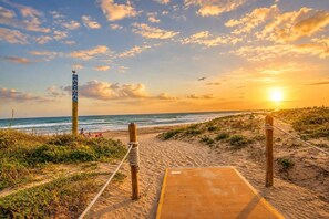 A beach path leading to the ocean with a wooden boardwalk and a signpost. - #17 | Modern SPI Studio | Beach Walk + Pool | Gulf (South Padre Island)