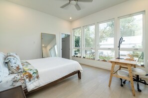 A bedroom with a bed, a desk, and large windows. - La Holly Rooftop Retreat (Austin)