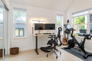 A home office with a desk, computer, and exercise equipment. - La Holly Rooftop Retreat w/ hot tub (Austin)