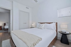 A modern bedroom with a large bed, bedside tables, and a door. - Spacious 2 Bedroom w/ Balcony in Placemakr Austin Downtown | Onsite Pool (Austin)