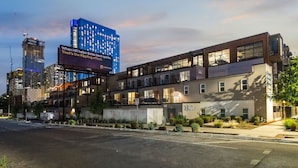 Ein modernes Hotel mit flachem Dach, mehreren Etagen und einer großen Werbetafel.