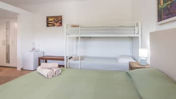 Une chambre avec un lit superposé, un bureau, une lampe et un tableau accroché au mur.