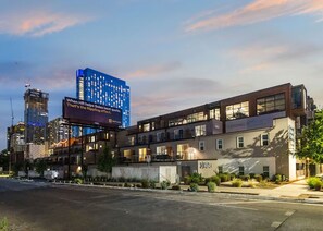 A modern hotel with a flat roof, multiple floors, and a prominent billboard. - Modern Room with Private Balcony + Pool view! | Near Museums (Austin)