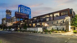 Et moderne hotel med fladt tag, flere etager og et iøjnefaldende skilt.