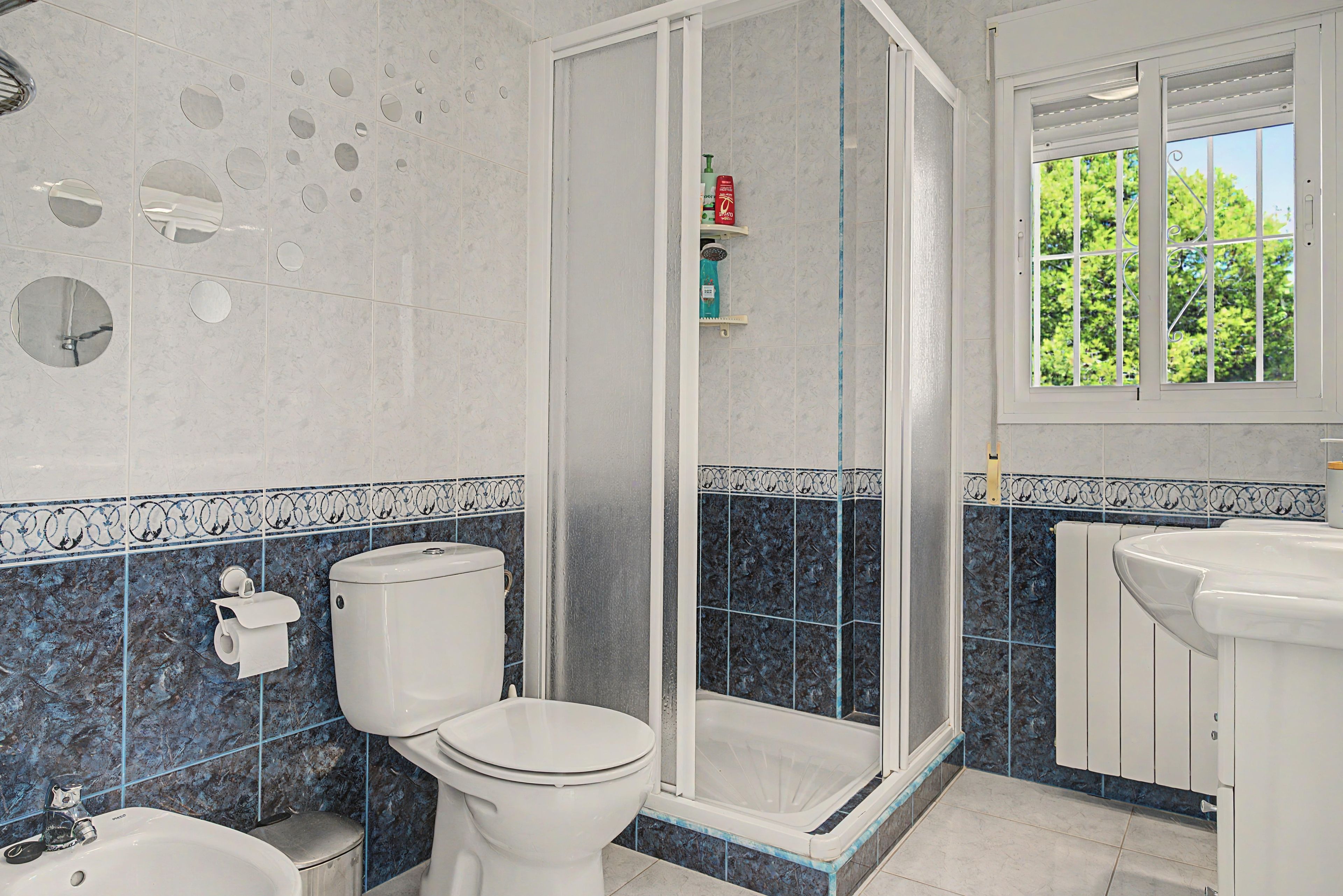 A bathroom with a toilet, bidet, and shower enclosure.