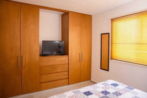 Ein Schlafzimmer mit einem Bett, einem Kleiderschrank und einem Fernseher.