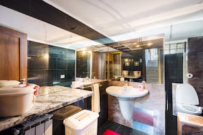 Un baño moderno con encimera de mármol, un lavabo y un inodoro.