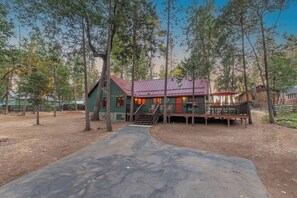 A rustic cabin with a porch, surrounded by trees. - The Gingerbread House | Sauna, HotTub, Lake Access (Twain Harte)