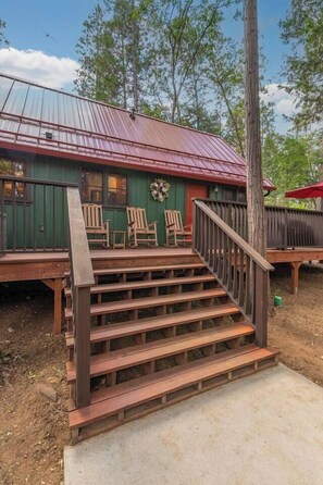 A wooden staircase leading to a porch with outdoor seating. - The Gingerbread House | Sauna, HotTub, Lake Access (Twain Harte)