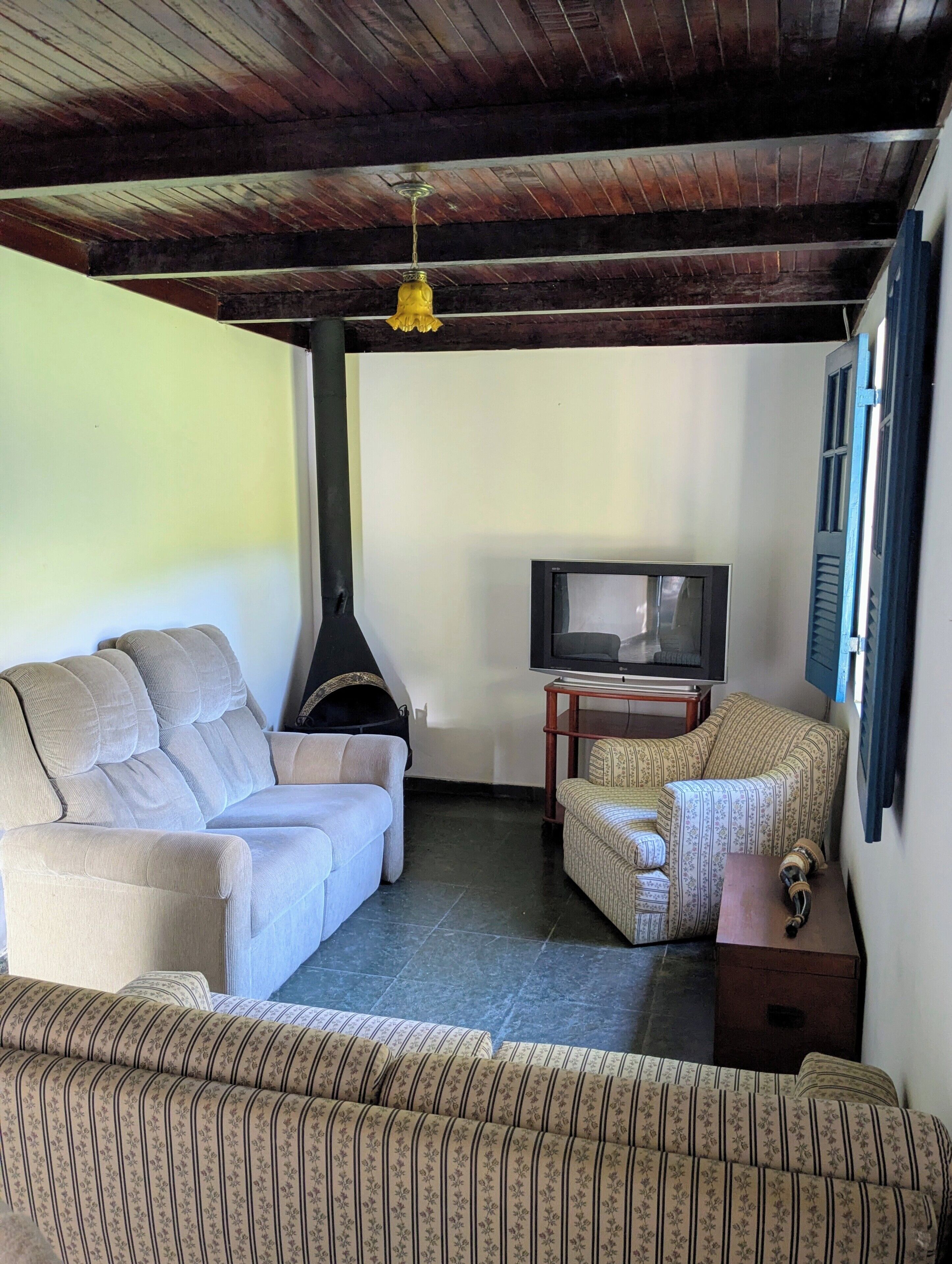 A living room with a sofa, armchair, television, and a fireplace.
