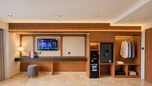 Un moderno vestíbulo de hotel con mostrador de recepción, televisor de pantalla plana, minibar y perchero.