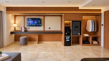 Um saguão de hotel moderno com balcão de recepção, televisão de tela plana, minibar e cabideiro.