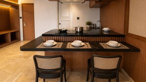 Una cocina moderna con una isla central, dos sillas y una mesa de comedor para cuatro.