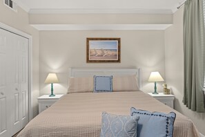 A bedroom with a large bed, two bedside tables, a nightstand, a framed picture on the wall, and a window with curtains. - Destin West ~ Sandpiper L07 ~ Walk Out Lanai with Private Grill ~ Lazy River (Fort Walton Beach)