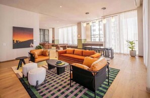 A modern living room with a sofa, ottomans, and a coffee table. - The Crosby 2BR Luxury City Views Balcony (Miami)