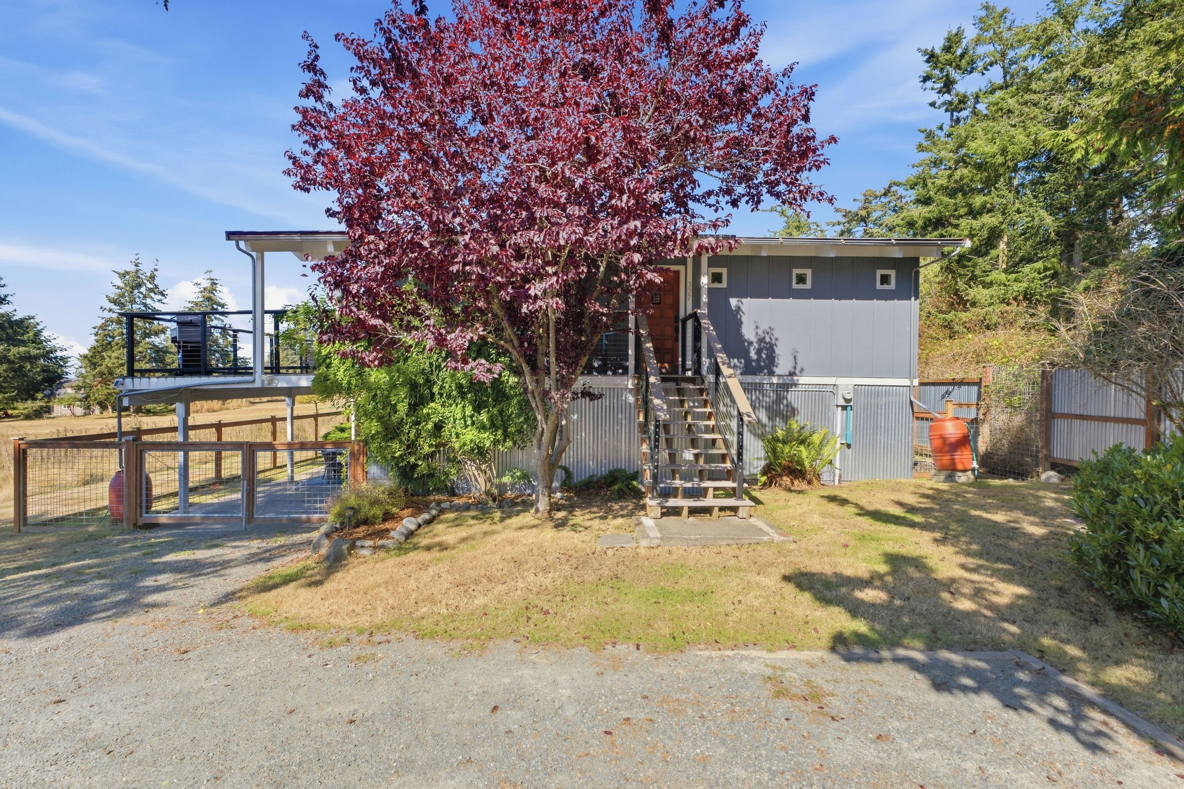 A residential property with a two-story house, a covered porch, and a small front yard.