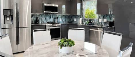 A modern kitchen with a central island, stainless steel appliances, and a water dispenser.