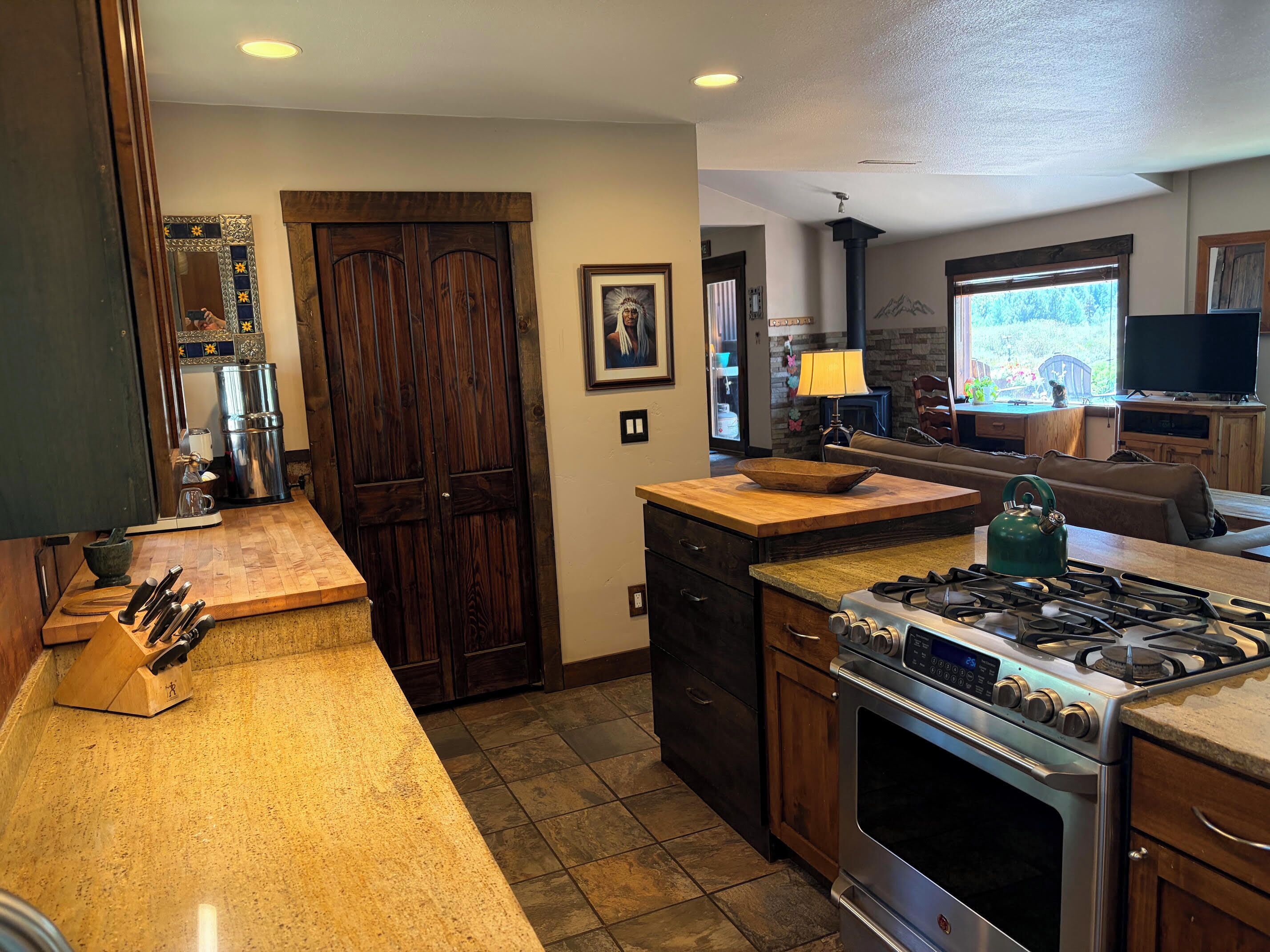 A kitchen with a gas stove, wooden cabinets, and a countertop.