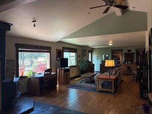 A cozy living room with a fireplace, wooden furniture, and a television. - 3-bedroom, 2-bath gated community of Blue River Valley Ranch Lakes (Silverthorne)