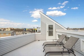 A rooftop terrace with two lounge chairs and a white door. - Rooftop Deck & Sunset Views, Avalon House (Avalon)