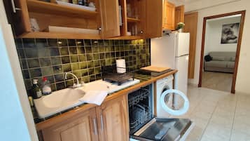 A kitchen with wooden cabinets, a sink, a dishwasher, and a refrigerator.