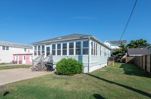 A single-story house with a covered porch, a small front yard, and a clear blue sky. - The Avalon House-2 Blocks to Avalon Pier, Vintage OBX Charm, Flex Stays All Year! (Kill Devil Hills)