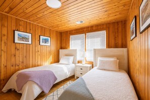 A room with two beds, wooden walls, and a window with blinds. - The Avalon House-2 Blocks to Avalon Pier, Vintage OBX Charm, Flex Stays All Year! (Kill Devil Hills)