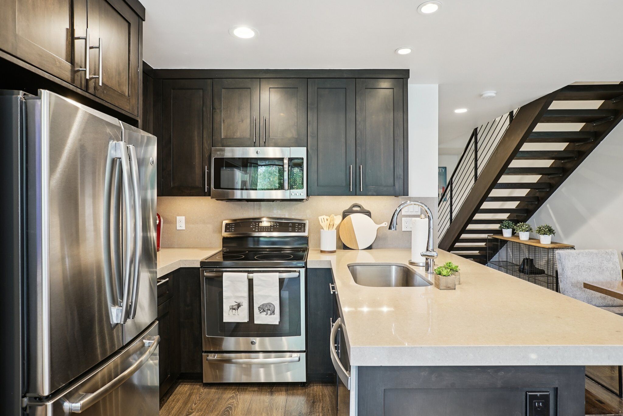 A modern kitchen with stainless steel appliances, a microwave, and a stove.