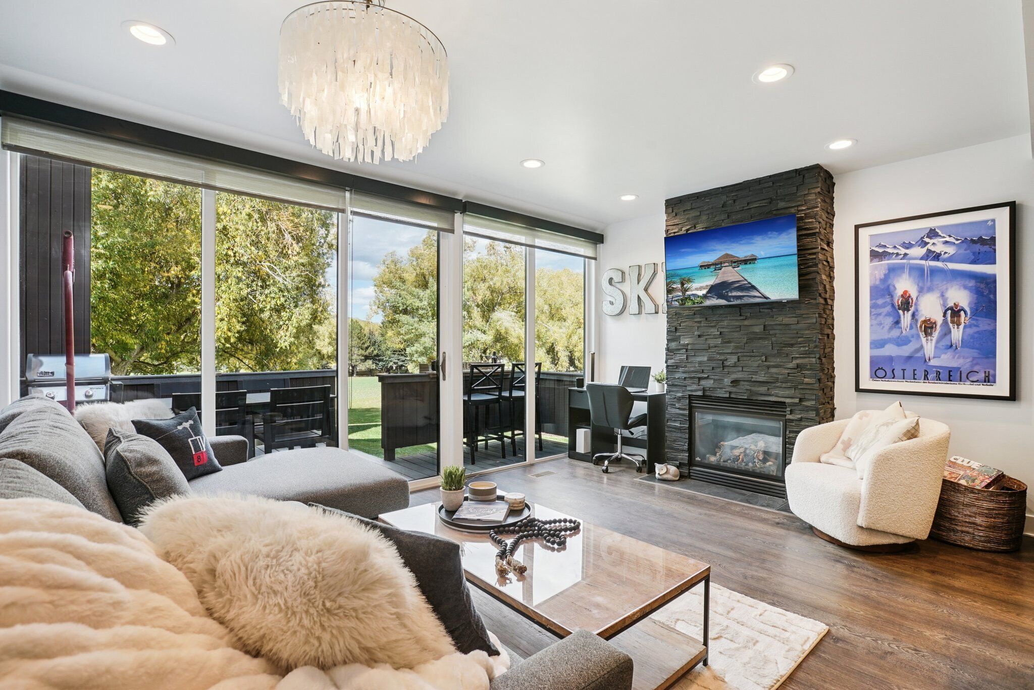 Una sala de estar moderna con chimenea, un ventanal y vistas al exterior.