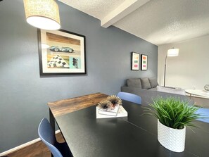 A modern living room with a dark wooden dining table, a sofa, and a potted plant. - South San Francisco Sweet Home-10 minutes to SFO (South San Francisco)