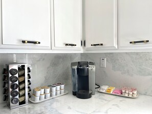 A kitchen with white cabinets, a coffee maker, and a spice rack with labeled containers. - South San Francisco Sweet Home-10 minutes to SFO (South San Francisco)