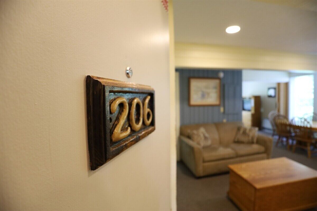 Une pièce avec une plaque numérotée sur le mur, un canapé et une table basse.