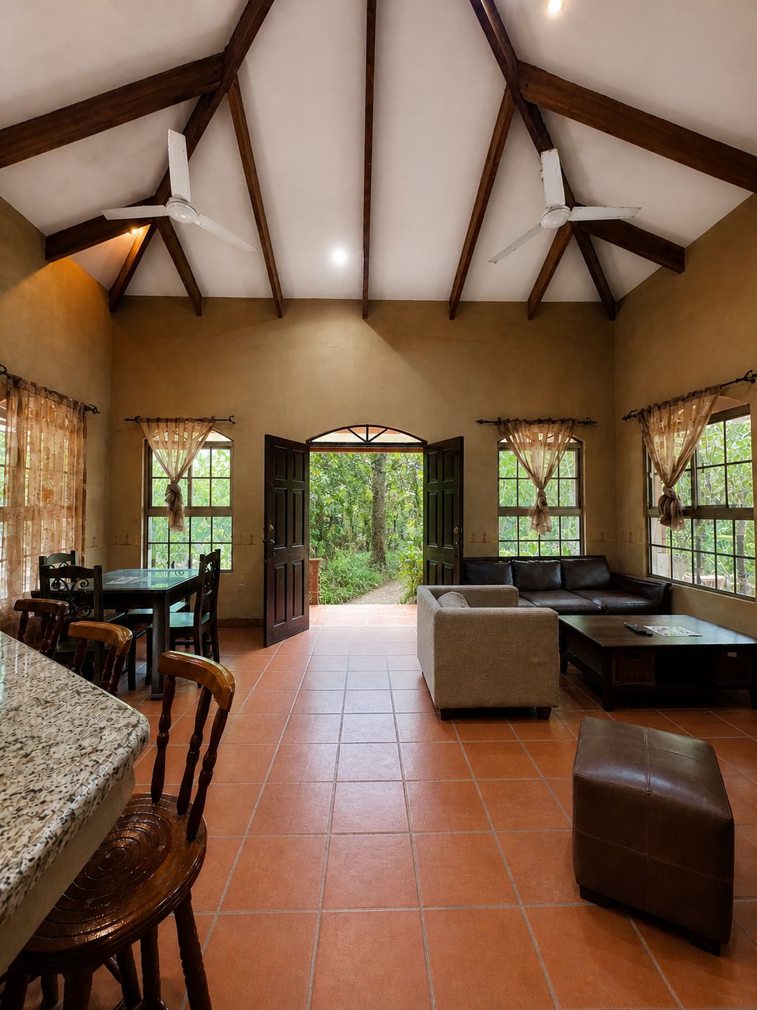 A spacious room with a dining area, seating, and a view through a doorway.