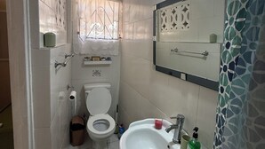 A bathroom with a toilet, sink, and a mirror above the sink. - Amazing ocean views (Castries)