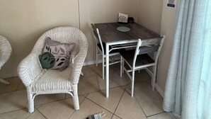 A room with a dining table, chairs, a cushioned chair, a rug, and a curtain. - Amazing ocean views (Castries)