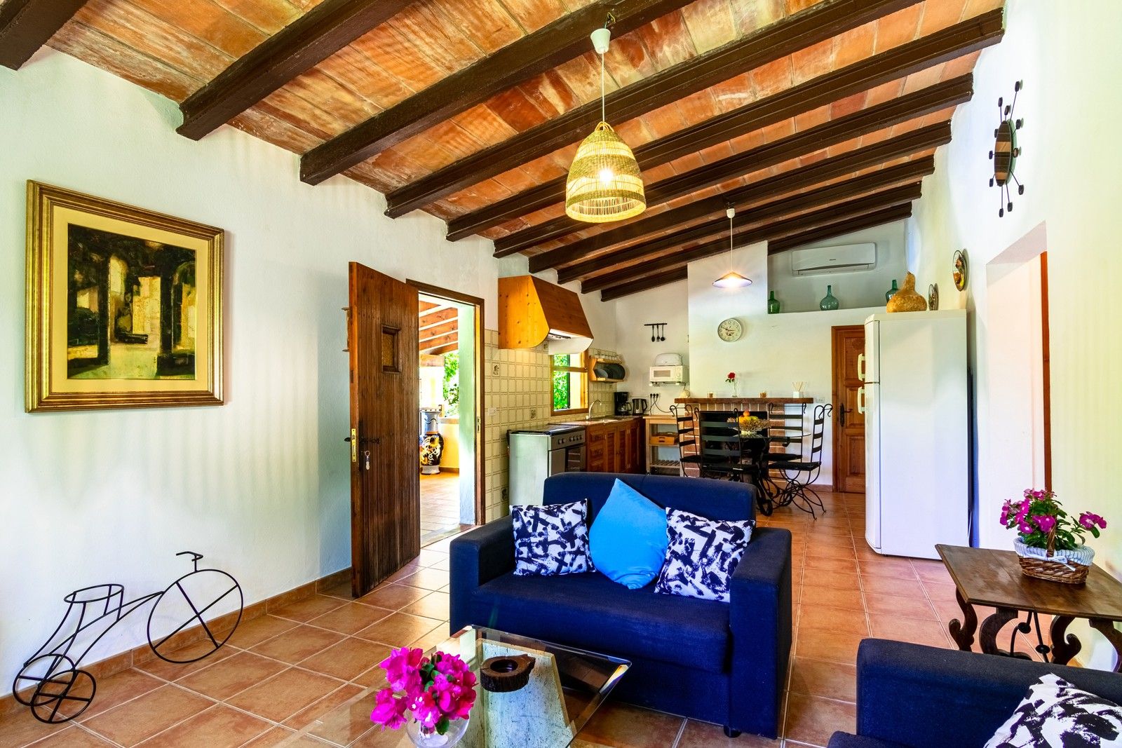 Un salón amplio con sofá, una mesa de comedor y una cocina al fondo.