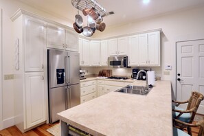 A kitchen with white cabinets, stainless steel appliances, a built-in oven, a microwave, and a sink. - "Hillside Hideaway" by OVR (Oxford)