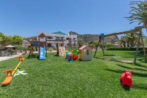 Ein Spielplatz mit Rutsche, Schaukeln und Klettergerüsten.