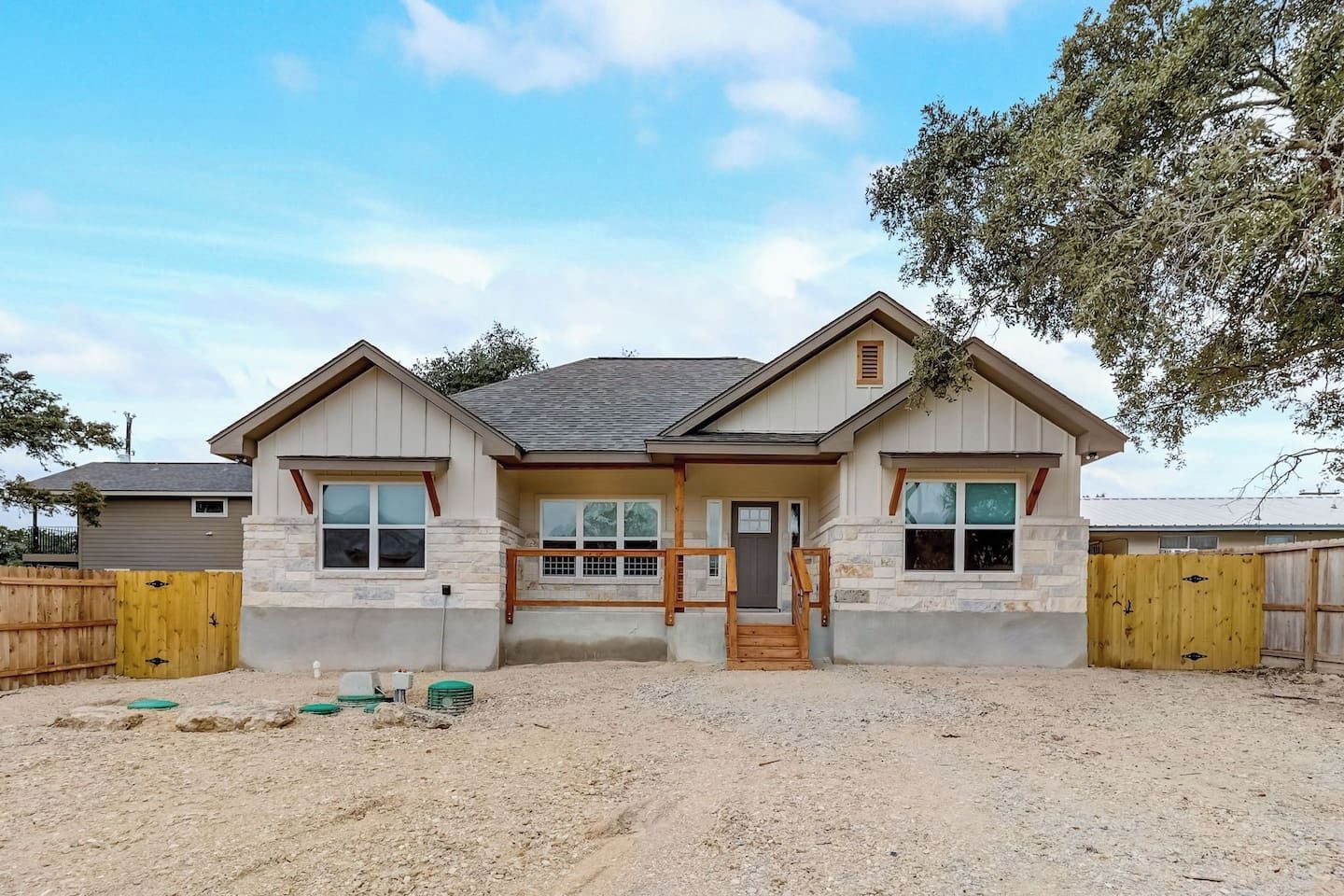 A two-story house with a front porch, a garage, and a fenced yard.