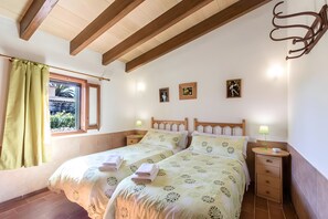 Ein Schlafzimmer mit zwei Betten, einem Fenster mit Blick und Nachttischlampen.