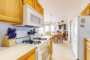 Una cocina con armarios de madera, una estufa blanca y un refrigerador.