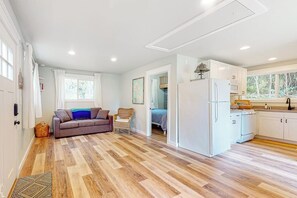 Een modern interieur met een zithoek, kitchenette en slaapkamer.